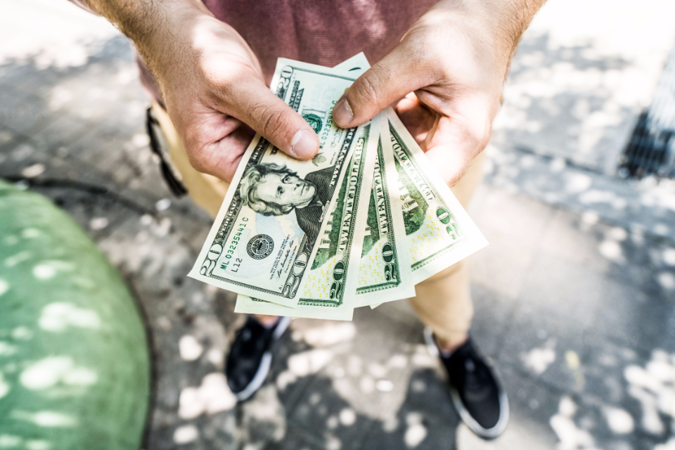 Hands holding cash, representing a cash for keys payment