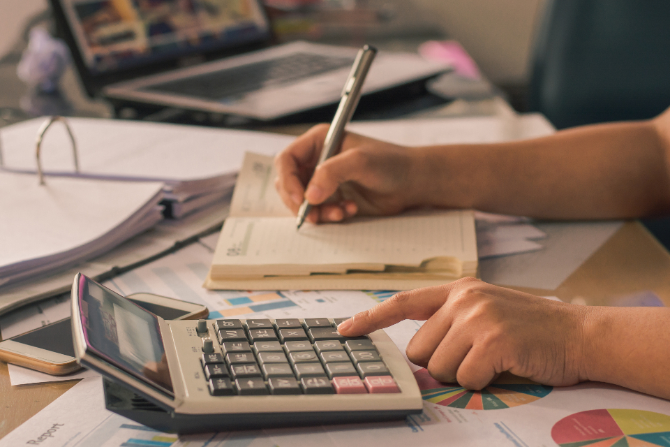 Hands using a calculator to estimate property taxes