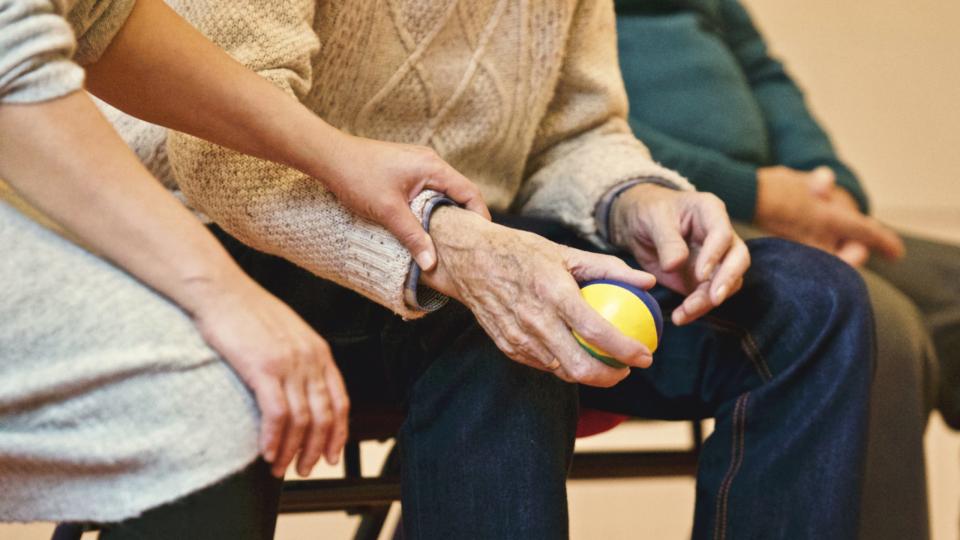 Caregiver holding the hands of an older adult