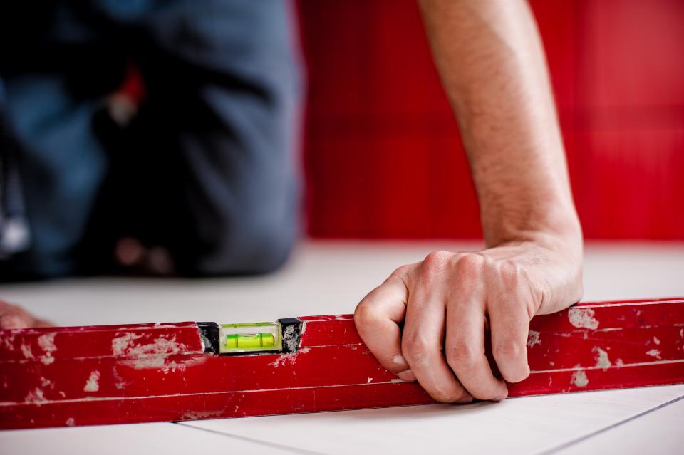 Contractor using a level during home repair work