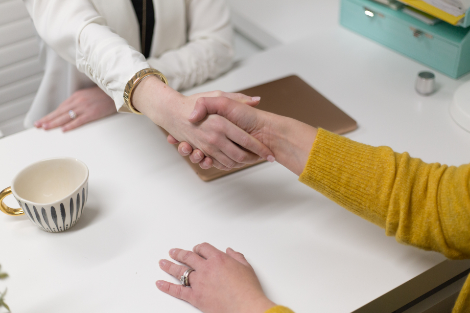 Handshake across a table after agreeing on a home sale