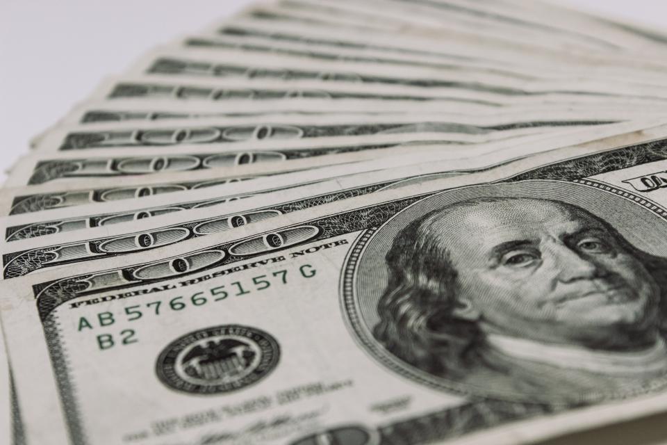 Stack of hundred dollar bills representing profit from a home sale